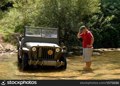 a man near to his military vehicle in the river