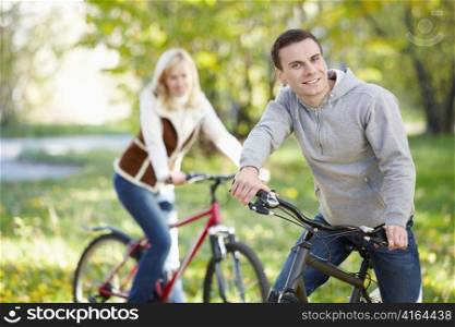 A man on a bicycle in the park in the foreground