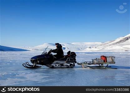 A man on a snowmobile against a winter landscape
