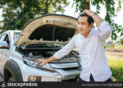 A man opens the hood of a car to repair the car due to a breakdown.