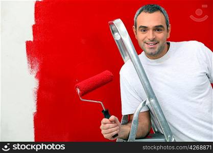 A man painting a wall red