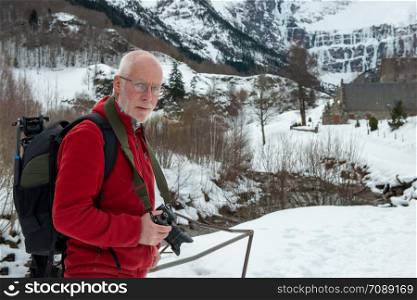 a man photographer with camera in the snowy mountain