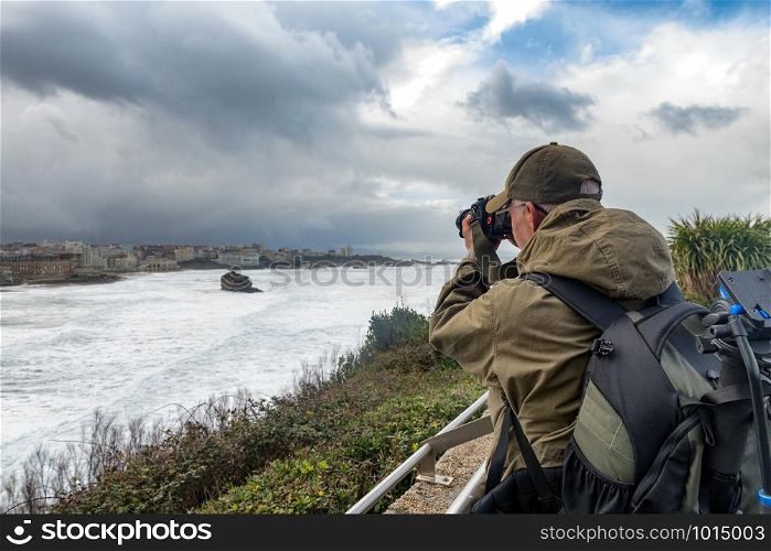 a man photographer working during a storm in Biarritz France