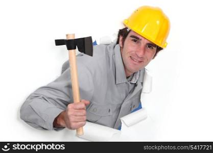 A man popping out a wall in paper with a hatchet.