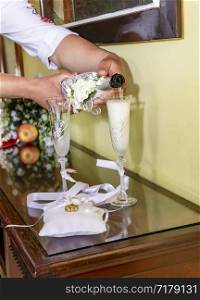 A man pours champagne in the into an elegant glass. Wedding celebration