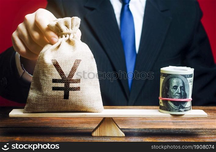 A man puts a Yen yuan money bag on the scales opposite to the dollar. Exchange rate, comparison of economic indicators. Avoiding savings inflation. Investments in foreign currency bonds.