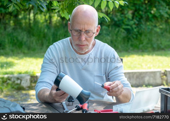 a man repairing a hair dryer for woman