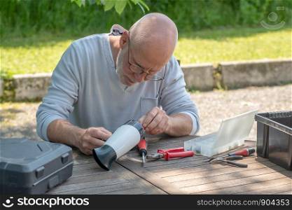 a man repairing a hair dryer for woman