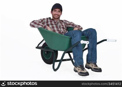A man resting in a wheelbarrow.