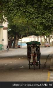 A man riding a Pedicab on the road, Havana, Cuba