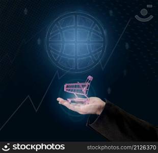 a man&rsquo;s hand holds a miniature shopping cart on a dark blue background, the concept of the start of world sales, the growth of purchases. Online shopping