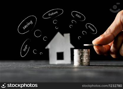 A man&rsquo;s hand is arranged on a wooden board and has an icon for growing the money to buy a home.