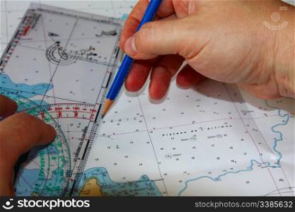 A Man&rsquo;s Hand Plotting a Route on a Maritime Chart