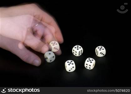 A man&rsquo;s left hand turning the dice, cheating at a game