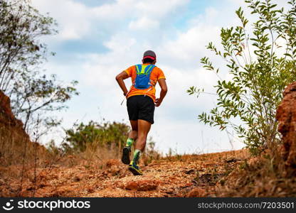 A man Runner of Trail . and athlete&rsquo;s feet wearing sports shoes for trail running in the mountains