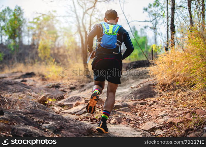 A man Runner of Trail . and athlete&rsquo;s feet wearing sports shoes for trail running in the forest