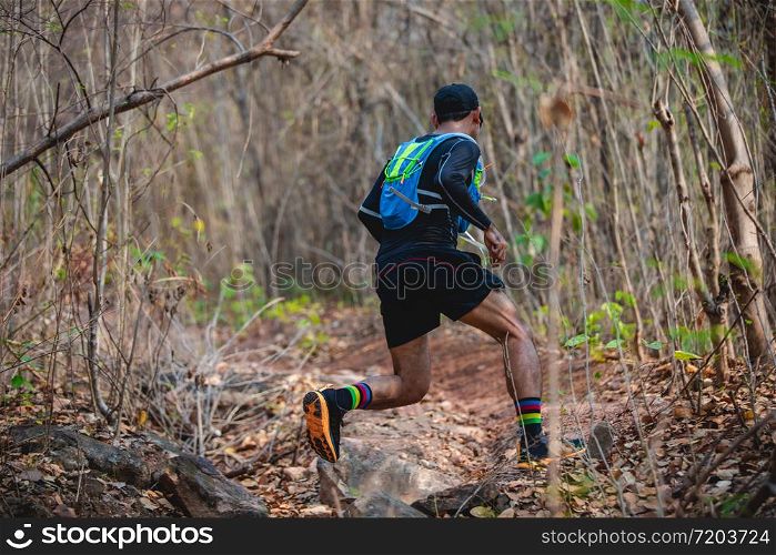 A man Runner of Trail . and athlete&rsquo;s feet wearing sports shoes for trail running in the forest