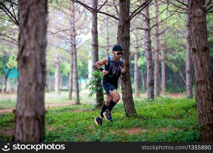 A man Runner of Trail and athlete&rsquo;s feet wearing sports shoes for trail running in the forest