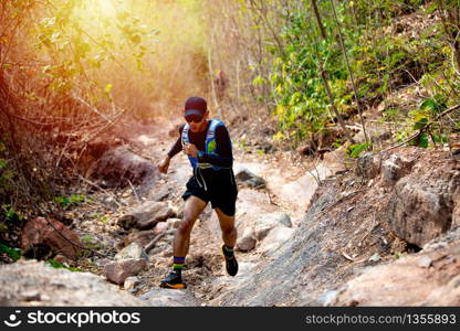 A man Runner of Trail and athlete&rsquo;s feet wearing sports shoes for trail running in the forest