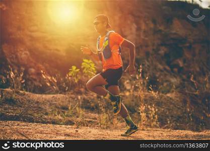 A man Runner of Trail and athlete&rsquo;s feet wearing sports shoes for trail running in the mountain