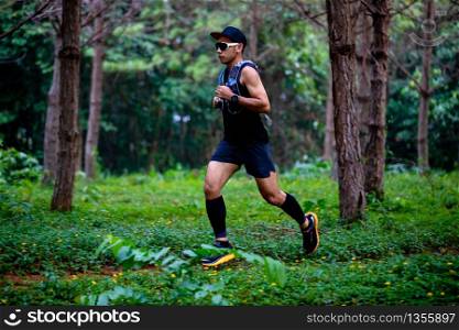 A man Runner of Trail and athlete?s feet wearing sports shoes for trail running in the forest