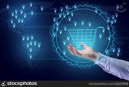 a man’s hand holds a virtual shopping cart against the background of a world map with points of sale. Internet sales concept, profit growth due to market expansion