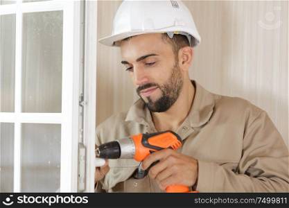 a man screws window frame