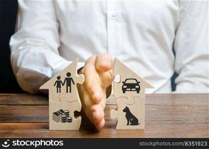 A man shares a house with his palm with images of property, children and pets. Divorce concept, property division process. Marriage contract, custody of children. The layer’s services