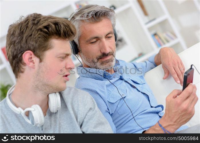 a man showing his son the playlist