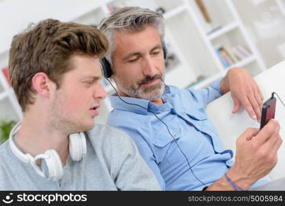 a man showing his son the playlist