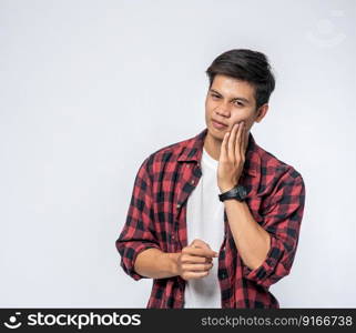 A man sick with a toothache and a hand holding on the cheek