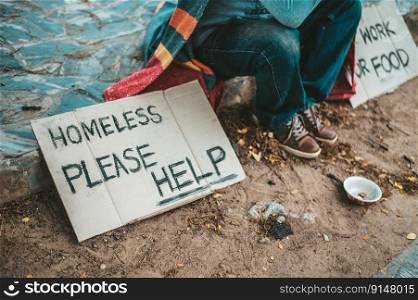 a man sitting beggars with homeless please help message. Selective focus.