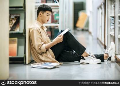 A man sitting reading a book in the library.