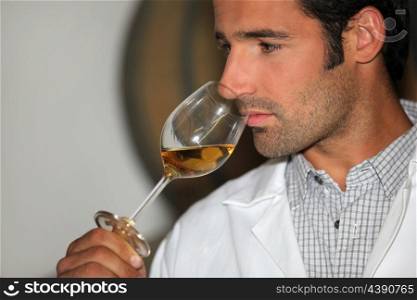 A man smelling wine