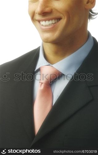 A man smiles and has perfect teeth and wears a smart suit.
