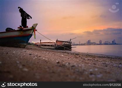A man stand on the Fishing boat wrecks on the beach