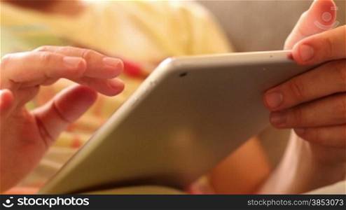 A man surfing the net with his iPad.Two hands touching the tablet screen and browsing.Leisure time touching iPad.