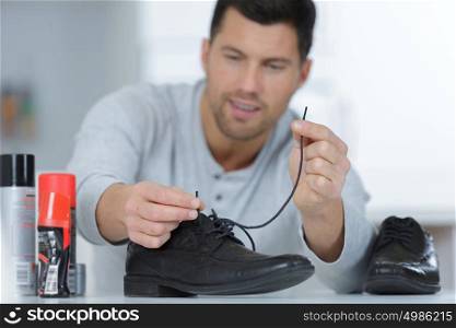 a man threading shoe laces