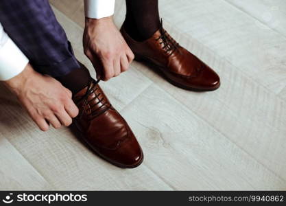 A man ties his shoelaces. Brown shoes.. man ties his shoelaces. Brown shoes.