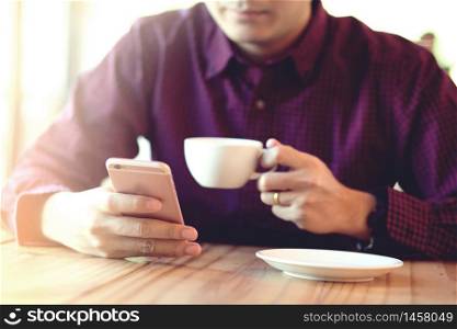 A man using a smartphone in a coffee shop