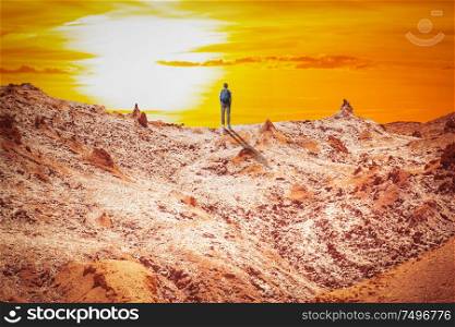 A man walks among the rocks of the Andes in the Atacama Desert