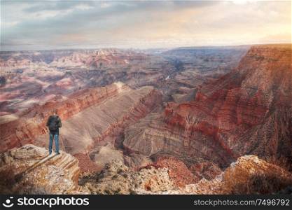 A man with a backpack on the edge of the cliff in Grand Canyon