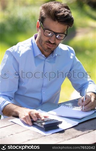 a man with a laptop sitting on a park bench
