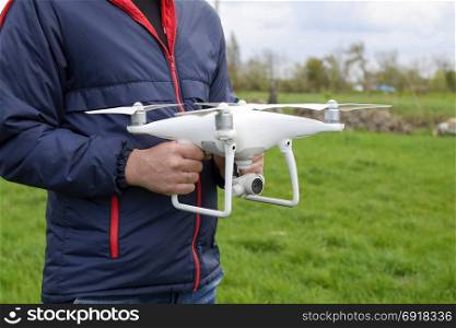 A man with a quadrocopter in his hands. A white drone is being prepared for the flight. Phantom. A man with a quadrocopter in his hands. A white drone is being prepared for the flight. Phantom.