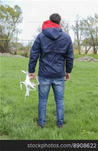 A man with a quadrocopter in his hands. White kvadrokopter prepare for flight.. A man with a quadrocopter in his hands. White kvadrokopter prepare for flight