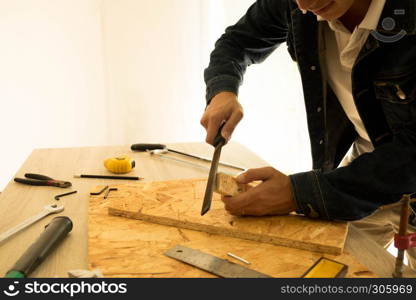 A man with a rasp in his hands wood plank