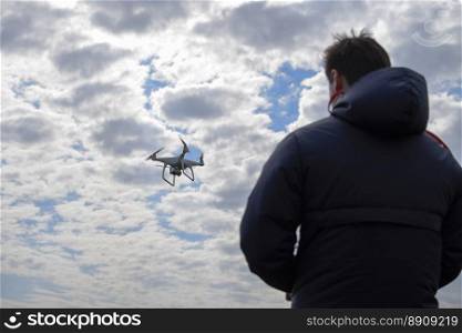 A man with a remote control in his hands. Controlling the flight of the drone against the sky. Phantom. A man with a remote control in his hands. Controlling the flight of the drone against the sky. Phantom.