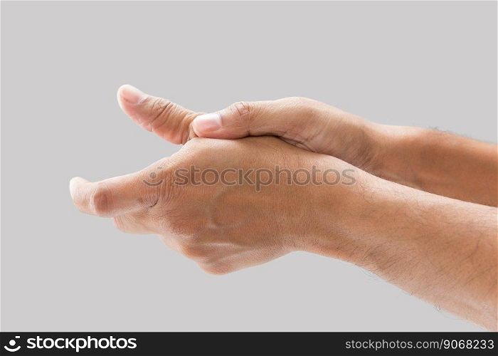 A man with thumb pain on a gray background.