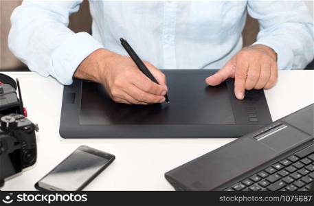 a man working on his graphics tablet, close up of hands