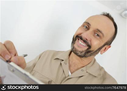 a man writing in clipboard